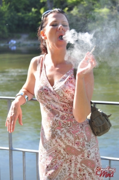 Brunette babe smoking at the riverside